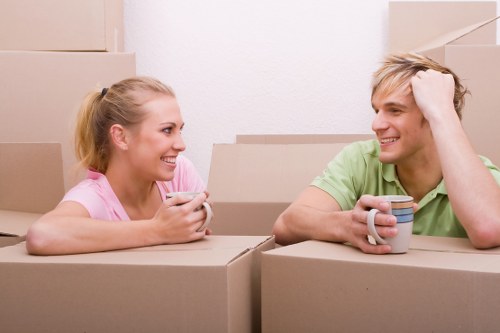 Professional movers carrying furniture through a narrow London property staircase
