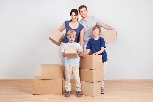 Movers carrying furniture down stairs in a Kentish Town flat